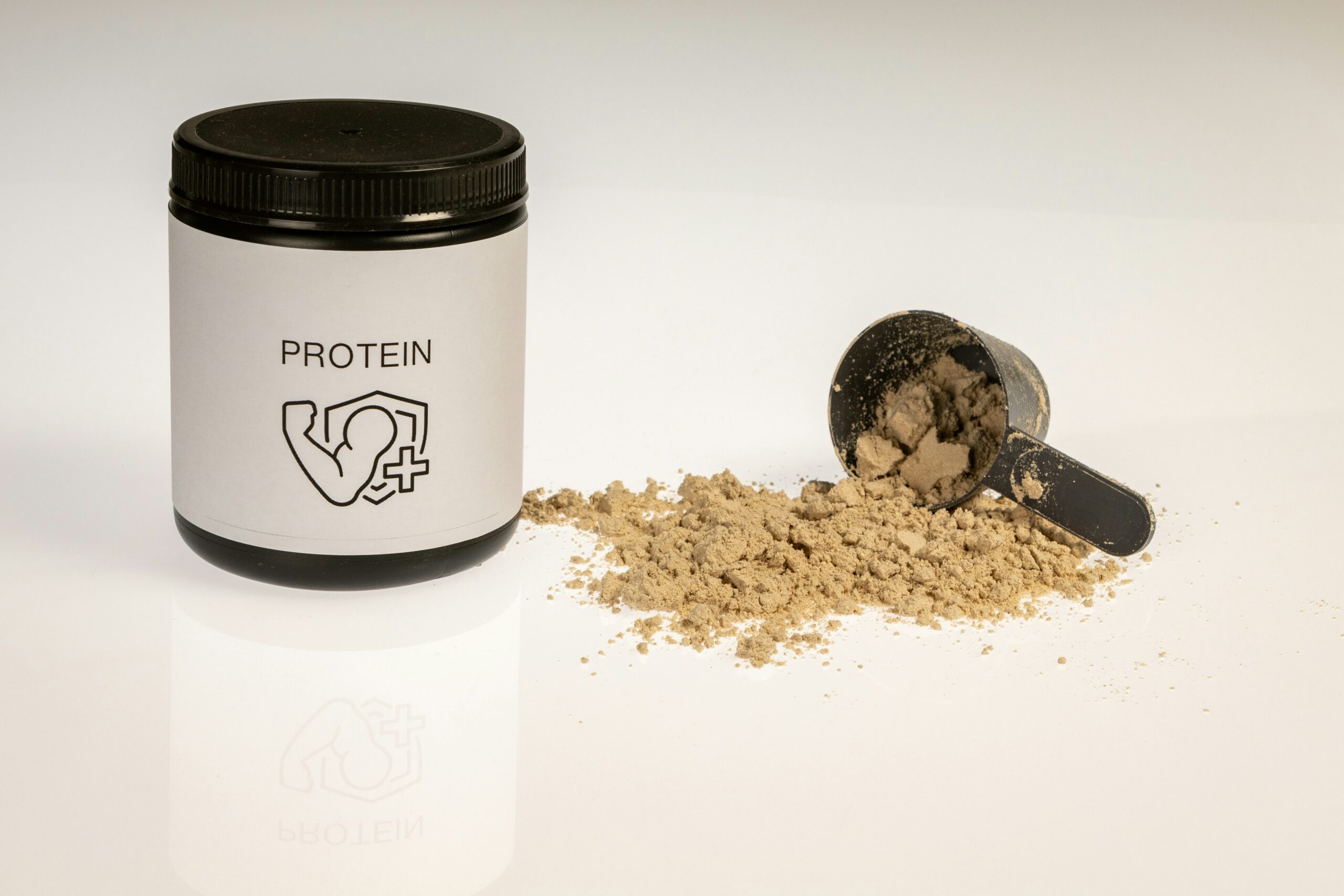 Whey protein powder with black scoop and container for muscle growth and fitness nutrition.