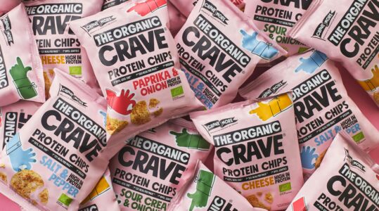 The Organic Crave protein chips variety pack featuring paprika and onion, salt and pepper, sour cream and onion, and cheese flavors in pink packaging, high-protein organic snack chips displayed flat lay.