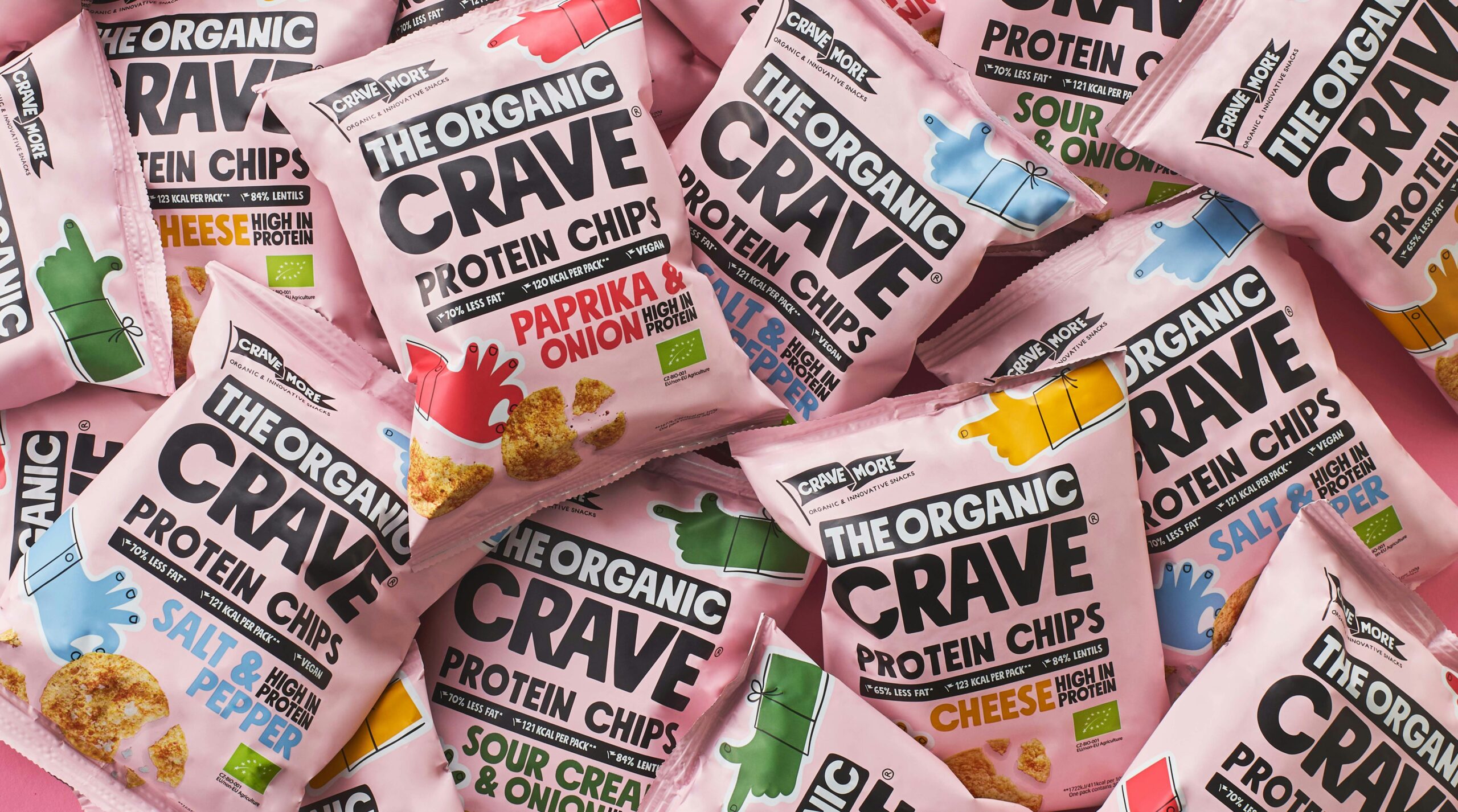 The Organic Crave protein chips variety pack featuring paprika and onion, salt and pepper, sour cream and onion, and cheese flavors in pink packaging, high-protein organic snack chips displayed flat lay.
